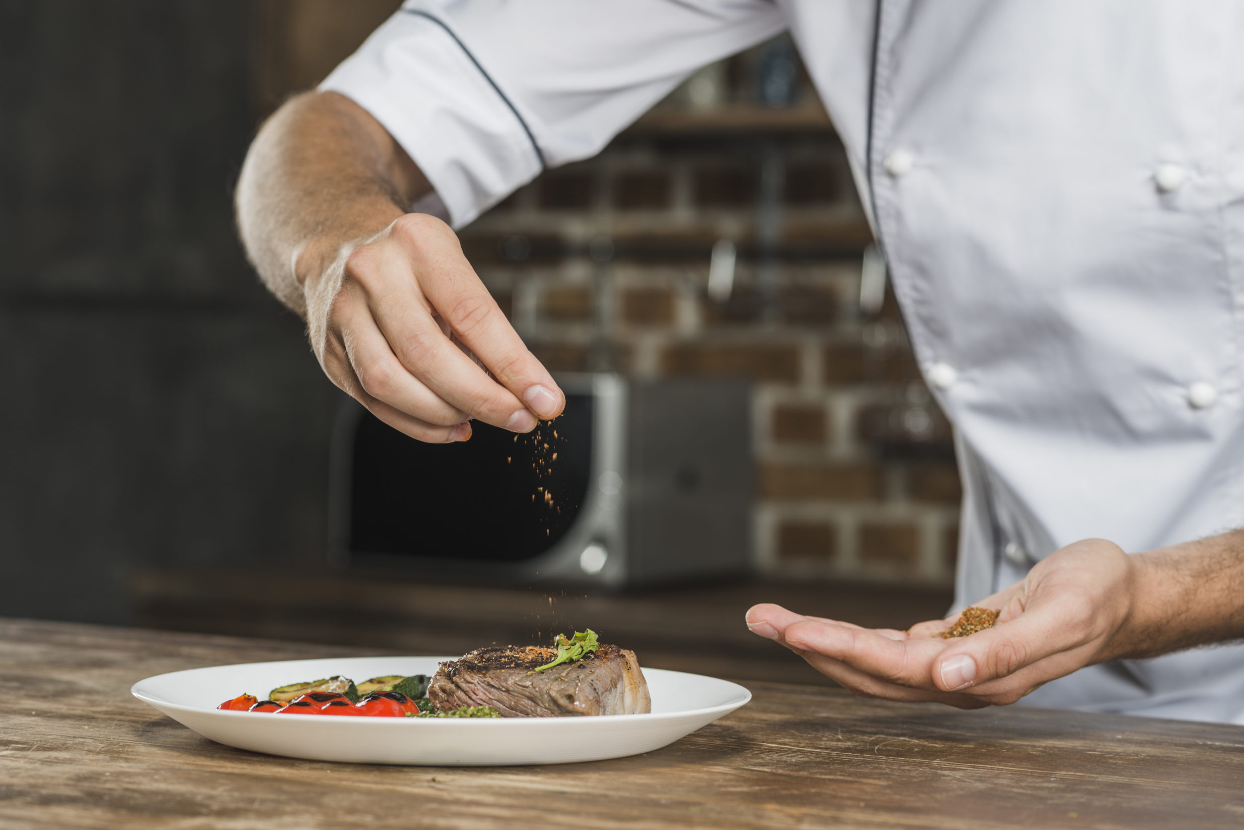 Cuisinier assaisonnant un plat